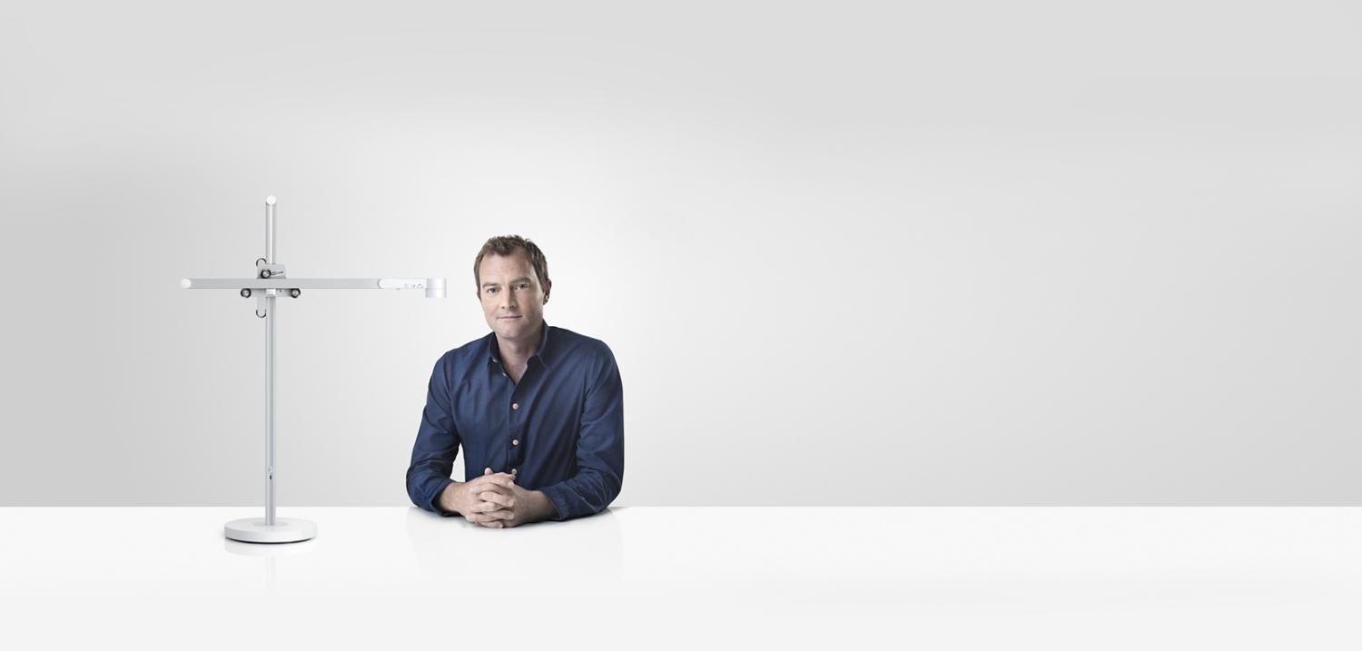 Jake Dyson sitting next to the Dyson Lightcycle™ task light